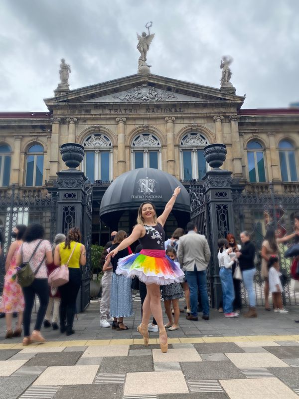 Ana Luisa Venegas, fundadora de Ballet Tico, posando en puntas frente al Teatro Nacional